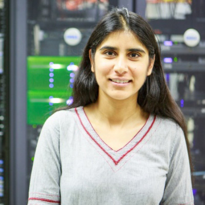 Darakhshan Mir. Assistant Professor, Bucknell University. Wearing a grey sweater in front of a bay of computers / technology servers.