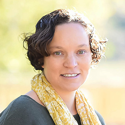 Sarita Schoenebeck. Associate Professor, University of Michigan. Wearing a dark colored shirt and a yellow scarf.