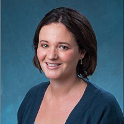 Margot Kaminski. Associate Professor of Law, University of Colorado Law School. Wearing a blue shirt in front of a blue backdrop.
