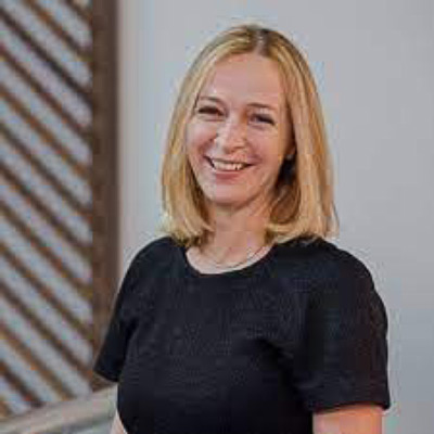 Cornelia Kutterer. Microsoft. Wearing a dark shirt in front of a light grey background, downward horizontal pattern over their shoulder.