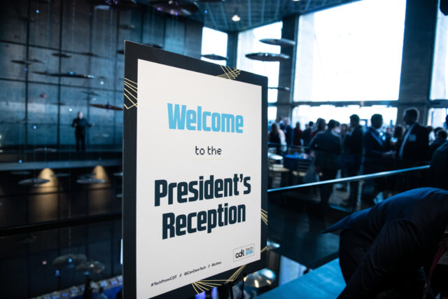 Sign at the President's Reception, from the 2022 Tech Prom. A full room of tech policy thinkers and doers in the background.