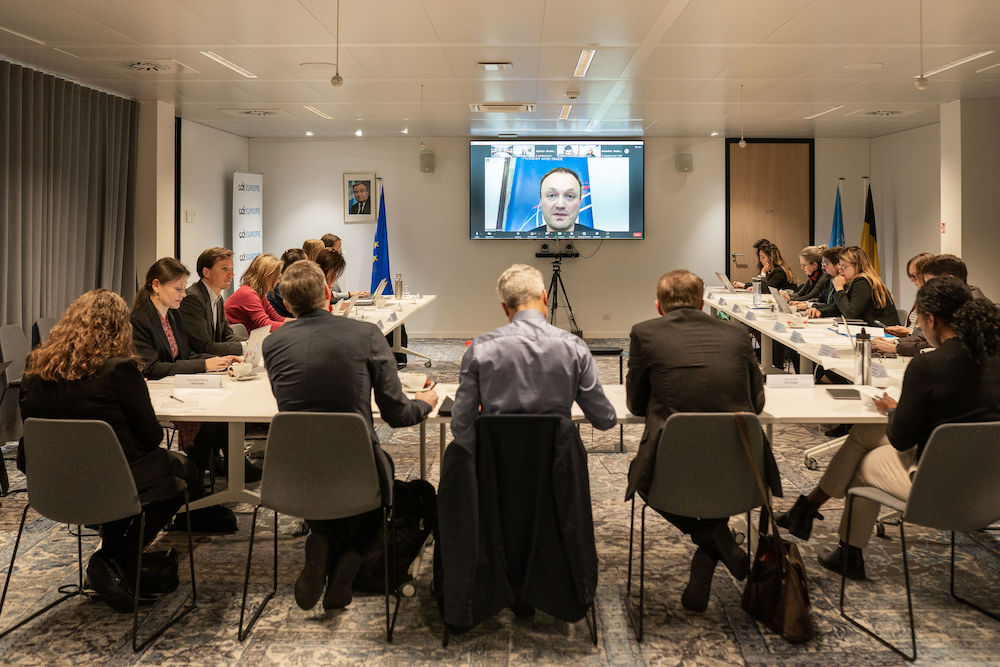 Photograph of 19 participants seated at a u-shaped table with hanging microphones. A screen is transmitting the video conference, with Mr. Petr Očko, Deputy Minister for Digitisation and Innovation from the Ministry of Industry and Trade of the Czech Republic at the forefront. Frédéric Bokobza, Deputy Director General of ARCOM and President of Subgroup 2 of ERGA, wears a grey shirt, and sits at the front middle of the meeting room. On his right side, Werner Stengg, Digital Expert, Cabinet of Executive Vice President of the European Commission and Commissioner for Competition, wears a black jacket. Right next to him, Asha Allen, Advocacy Director for Europe and Civic Space at CDT Europe, and moderator of the panel, wears a black sweater and trousers. On the left side, David Reichel, Project Officer at the Data and Digital Sector in Justice from the EU Fundamental Rights Agency, wears a grey jacket. Iverna McGowan, Director of CDT Europe, wears a black jacket. The other participants seated in the room are members of civil society organisations.Photograph of 19 participants seated at a u-shaped table with hanging microphones. A screen is transmitting the video conference, with Mr. Petr Očko, Deputy Minister for Digitisation and Innovation from the Ministry of Industry and Trade of the Czech Republic at the forefront. Frédéric Bokobza, Deputy Director General of ARCOM and President of Subgroup 2 of ERGA, wears a grey shirt, and sits at the front middle of the meeting room. On his right side, Werner Stengg, Digital Expert, Cabinet of Executive Vice President of the European Commission and Commissioner for Competition, wears a black jacket. Right next to him, Asha Allen, Advocacy Director for Europe and Civic Space at CDT Europe, and moderator of the panel, wears a black sweater and trousers. On the left side, David Reichel, Project Officer at the Data and Digital Sector in Justice from the EU Fundamental Rights Agency, wears a grey jacket. Iverna McGowan, Director of CDT Europe, wears a black jacket. The other participants seated in the room are members of civil society organisations.