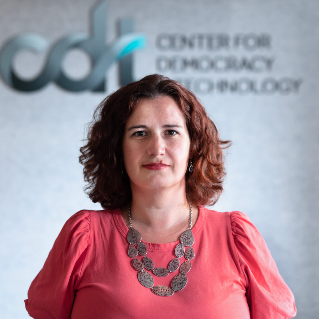Nathalie Maréchal, wearing a bright pink top and silver necklace in front of a CDT logo.