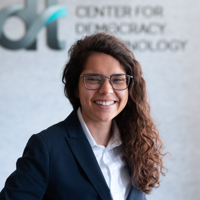 Ariana Aboulafia, wearing glasses and a blue suit and white collared shirt, in front of a CDT logo.