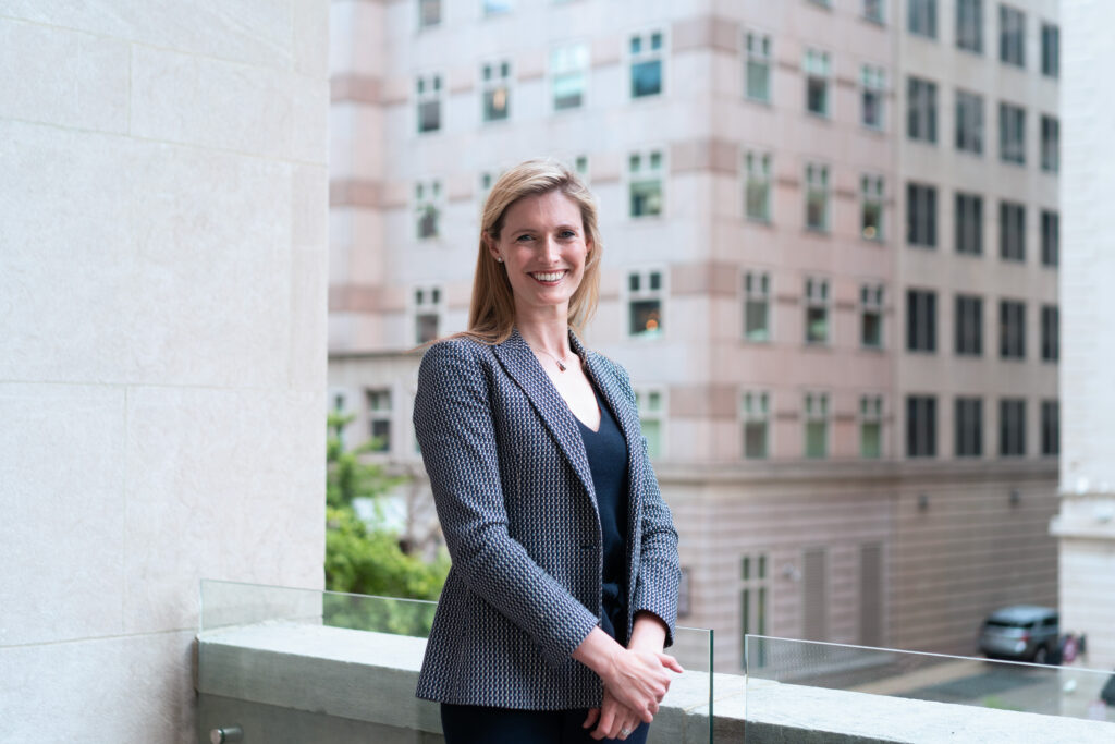 CDT President & CEO Alexandra Reeve Givens. Wearing a patterned jacket and blue dress, standing outdoors.