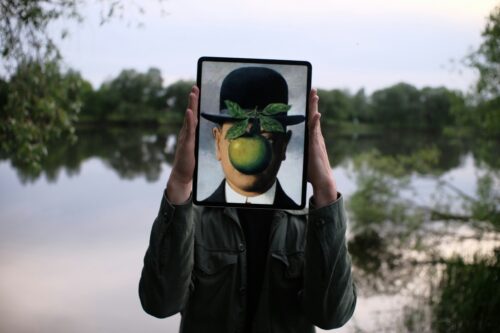 Person holding ipad over their face with famous painting.