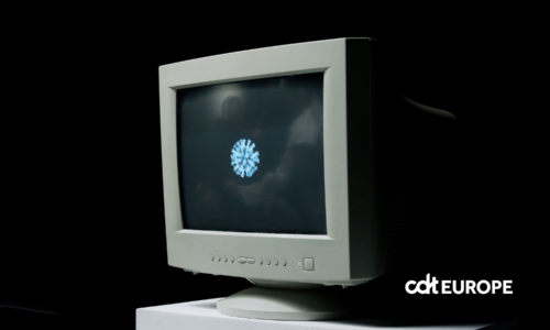A vintage computer monitor shows an image of a coronavirus on screen against a dark background.