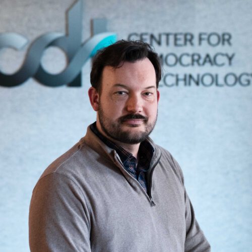 Geoff Hale, wearing a dark collared shirt and a brown half-zip sweater in front of the CDT logo.