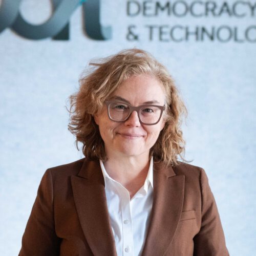 Sarah Zolad, smiling in front of the CDT logo and wearing a brown blazer and dark horn-rimmed glasses.