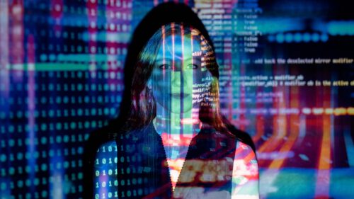 A woman's face overlaid with colorful computer code and binary numbers