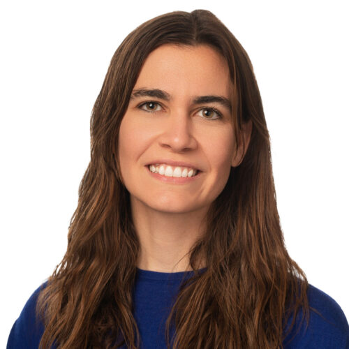 Sydney Saubestre, smiling in a dark blue top with long dark hair.