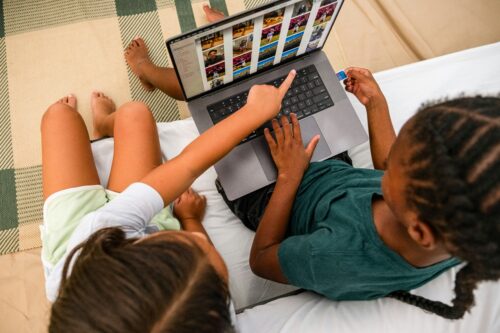 Two kids sharing a computer.