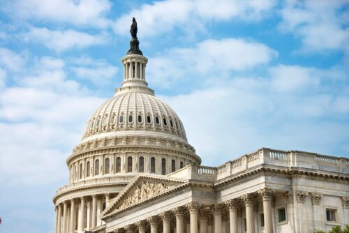The US Capitol seen against a blue sky with white clouds