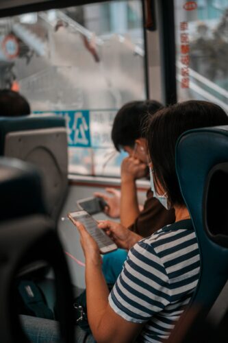 Woman using a phone while she rides a bus