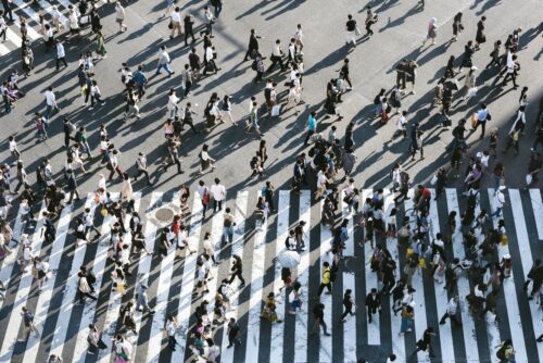 Picture of many people crossing a busy crosswalk
