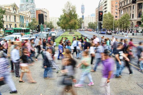 Semi-blurry photograph of a crowd of people moving about in a city