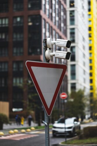 Surveillance cameras over a traffic sign.