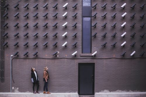 Surveillance cameras pointing down toward people.