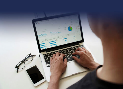 Photograph of a person reviewing financial information on a laptop computer