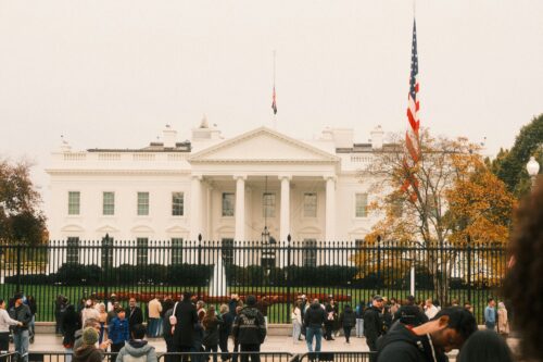 A photograph of people standing in front of the White House